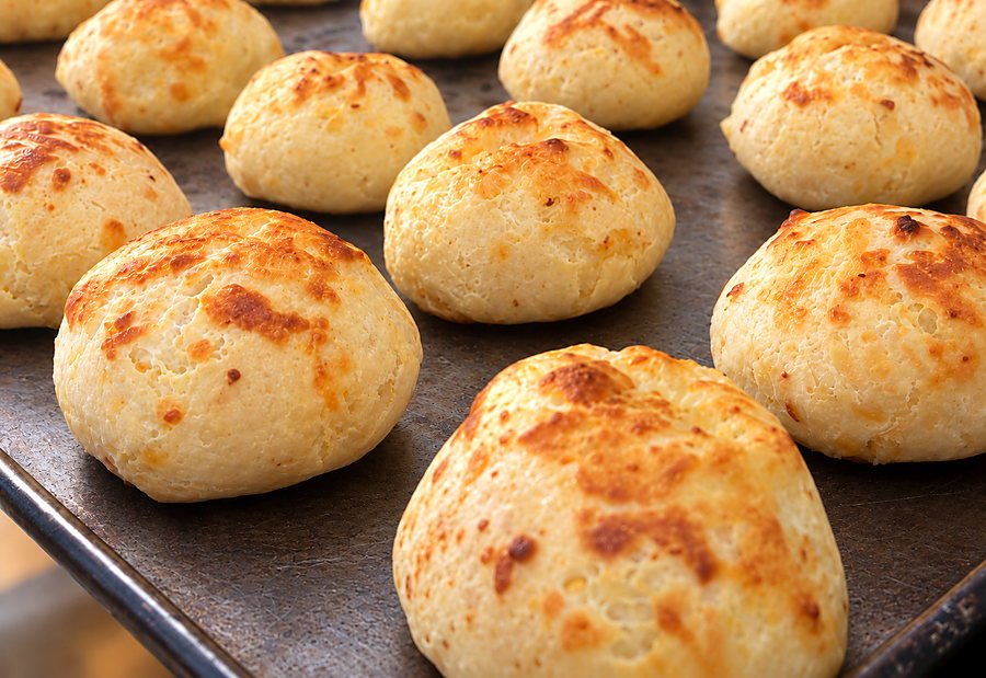 Bandeja de pães de queijo recém-assados, ainda na assadeira